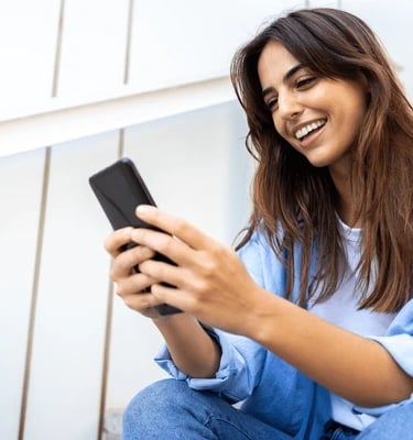 a woman sitting on steps with a cell phone