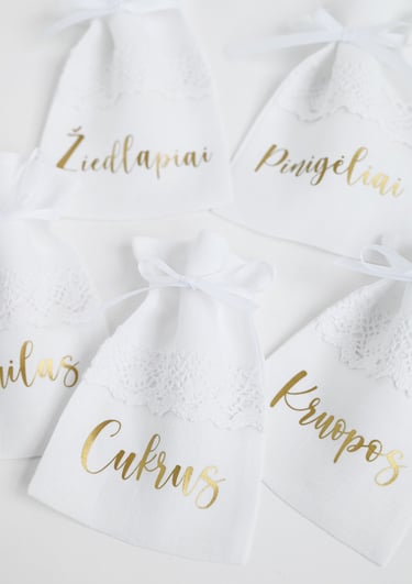 a group of wedding party favors with gold foil and white lace