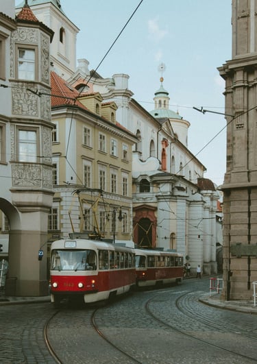 Ein roter Straßenbahnwagen fährt die Gleise herunter