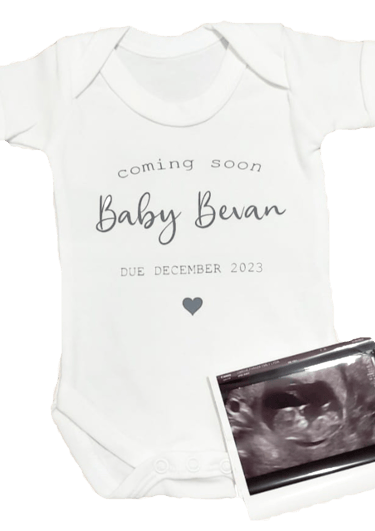 a baby's bodysuit with a baby's birth announcement