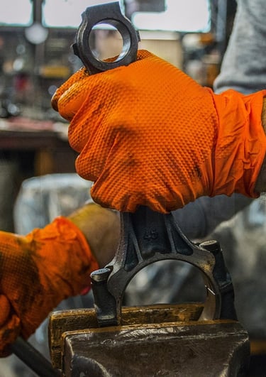 a man in an orange glove holding a wrench