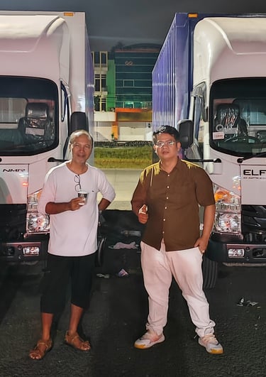 three men standing next to each other in front of a truck