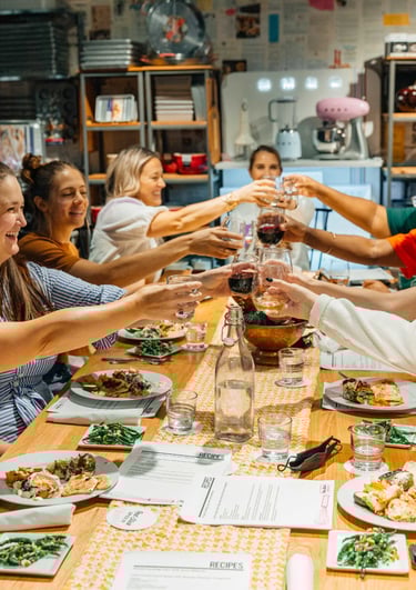 Corporate team clinking glasses at the dinner table during a celebratory team-building retreat