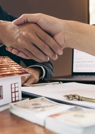 Poignée de main entre deux partenaires scellant la vente d’un hôtel touristique aux Caraïbes, symbolisant une transaction réu