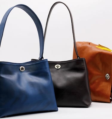 a pair of two handbags with a leather bag