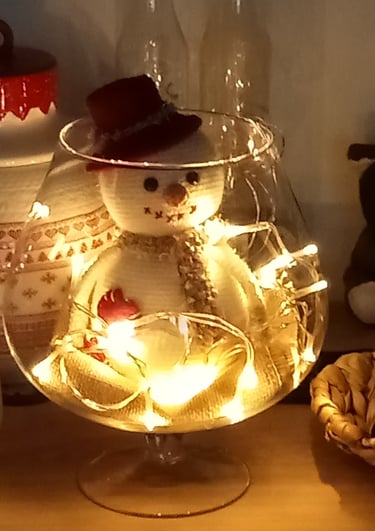 Bonhomme de neige avec une écharpe et un chapeau dans un grand vert à cognac
