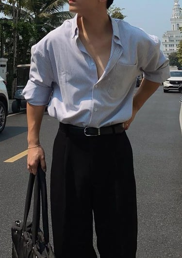 a man in a shirt and pants standing in the street
