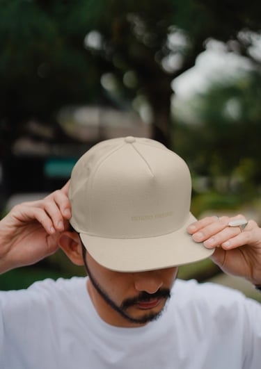 Hombre con gorra color crema y el logo de Sergio Freire bordado