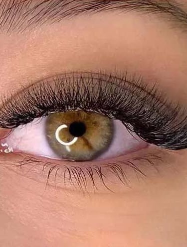 a woman's with volume eyelash extensions eye with a ring on her eye