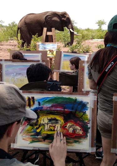 a group of people are painting an elephant on a field
