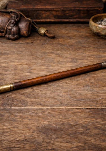 Antique wooden kiseru pipe with brass mouthpiece on a rustic wooden table with vintage smoking accessories.