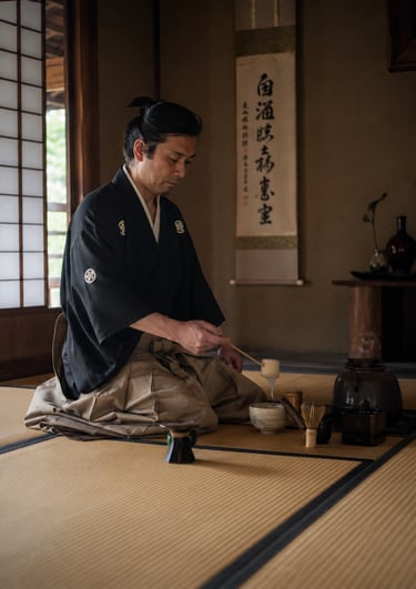 A man in traditional kimono performs a Japanese tea ceremony on tatami mats.