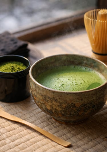 Traditional Japanese matcha green tea in a ceramic bowl with a bamboo whisk and scoop.