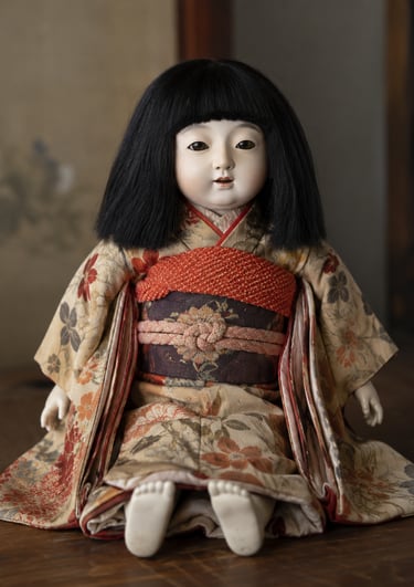 Antique Japanese Ichimatsu doll with black hair wearing a traditional floral silk kimono and obi.