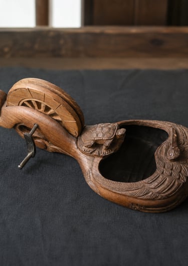 Antique Japanese hand-carved wooden sumitsubo ink pot featuring turtle and bird motifs on a dark surface.