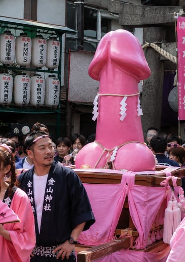 Crowds carry a large pink phallus statue on a shrine during the Kanamara Matsuri festival in Japan.