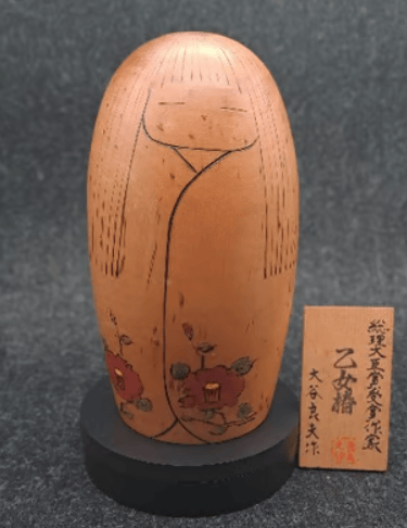 Vintage Japanese Sosaku Kokeshi wooden doll with hand-painted red camellia flowers.