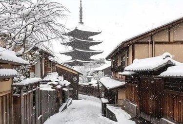 Snow-covered street in Kyoto's historic Higashiyama district with the Yasaka Pagoda in the background.
