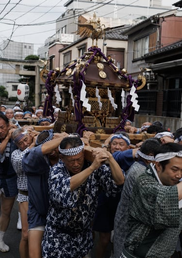 Japanese men carrying a golden mikoshi portable shrine during a traditional Shinto festival parade.