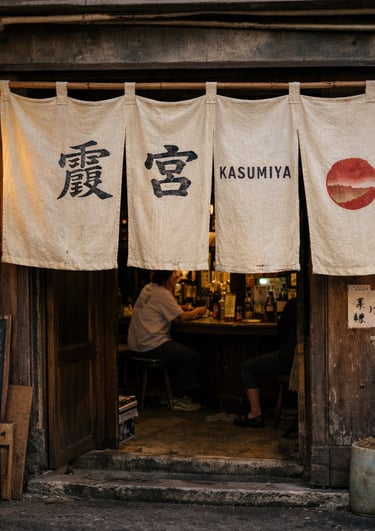 Traditional Japanese izakaya entrance featuring Kasumiya noren curtains and a lit paper lantern.