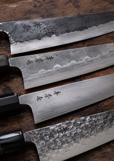 A collection of artisanal Japanese kitchen knives with wooden handles on a rustic wood surface.