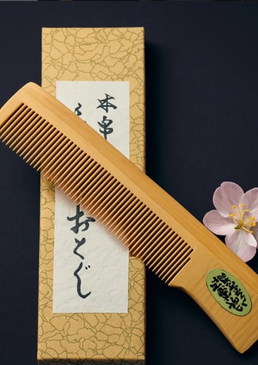 Traditioneller japanischer Holzkamm aus Tsuge, fein gearbeitet und neben Kalligrafiepapier sowie ein