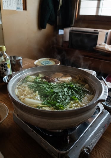 Steaming Japanese hot pot with tofu and leafy greens simmering in a clay nabe pot.