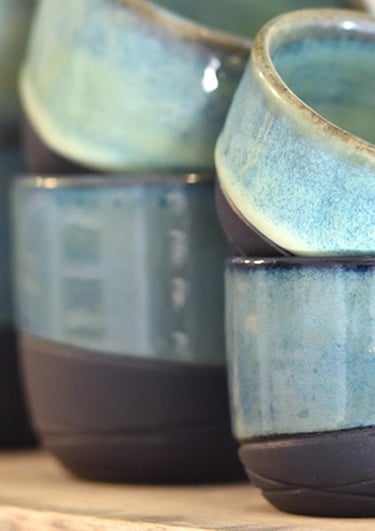 Handgemaakte espressokopjes koffiekopjes en theemokken van zwarte klei met groene en sage glazuur