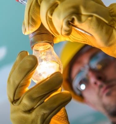 Changement d'une ampoule par un électricien pour imager un dépannage sur un défaut de lumière