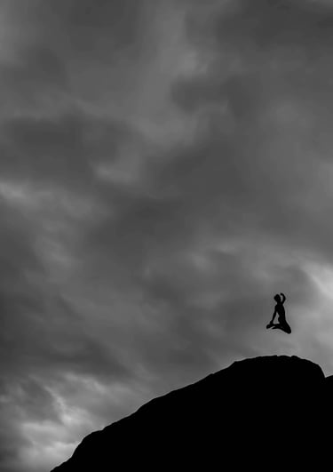 The shadow of a person jumping joyfully on a mountaintop, on a gray and cloudy day