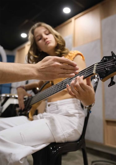 Joven estudiante aprendiendo guitarra y bajo en monochrome records