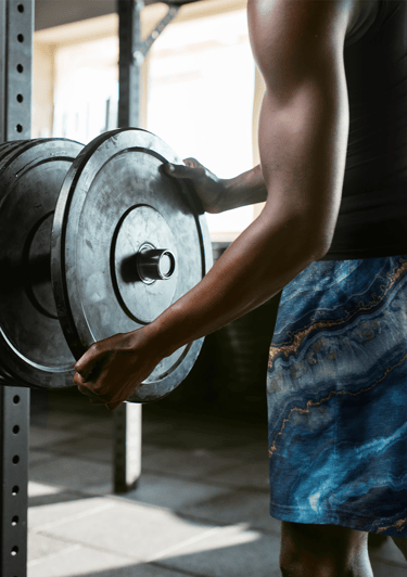 a man holding a large metal object in a gym