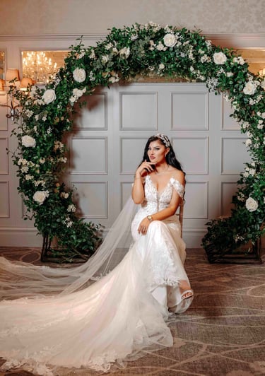 Bride posing under floral arch in wedding gown – Oxford wedding photography by Fred Art Studio