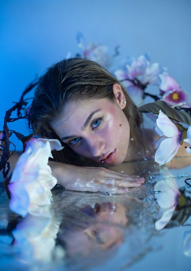 Sesión creativa de modelo rubia maquillada como sirena, con flores y espejo
