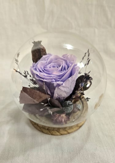 Rose éternelle et fleurs séchées, tons violet et bleu, sous cloche en verre ronde, créée par l'Ensorce'Fleurs