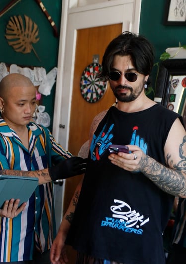 The tattoo artist is measuring the tattoo during the tattooing process for the customer.