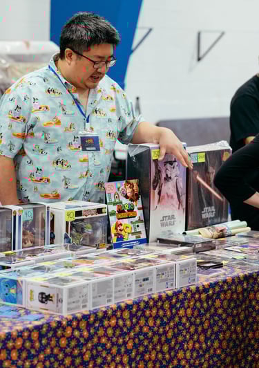 A vendor gestures to some of the nerdy items he has for sale.