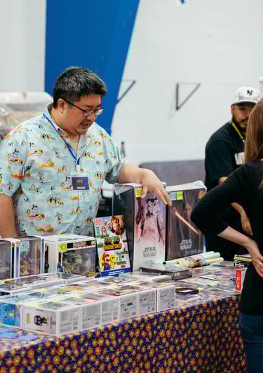 A vendor gestures to some of the nerdy items he has for sale.