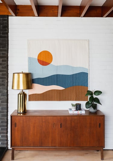 a painting of a sunset over a dresser