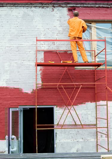 artisan qui peint une façade