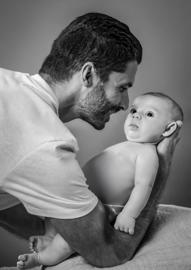 "Un retrato de familia en blanco y negro, padre con bebé en brazos"