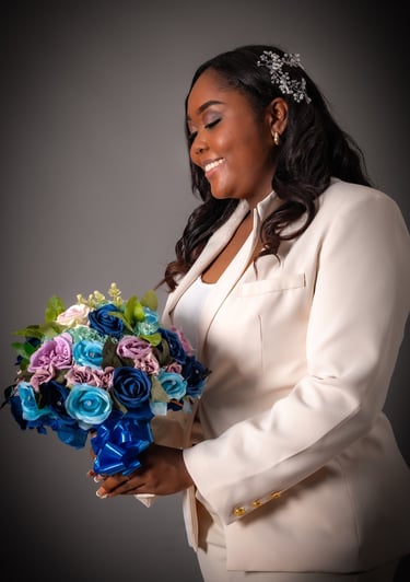 a woman in a white suit and a bouquet of flowers