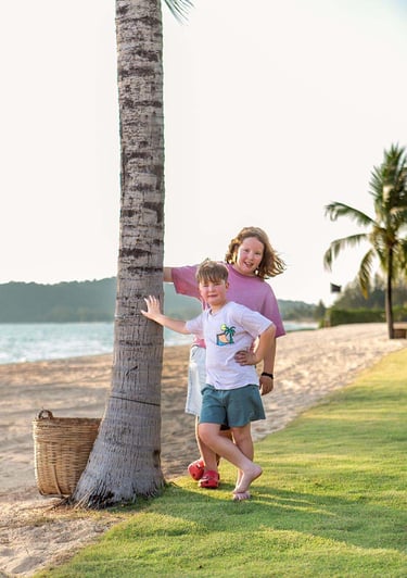 Siblings standing by a palm tree on Ong Lang Beach during a family photoshoot at Mövenpick Resort Ph