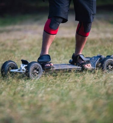 riding electric skateboard in grass