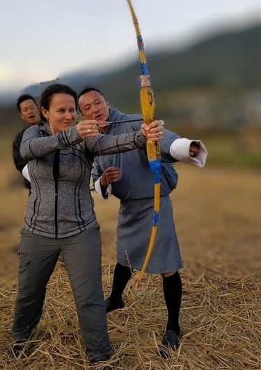 Drukyul_Delights_CEO_with_Guest_trying_traditional_Bow_and_arrow_during_guided_Archery_Session