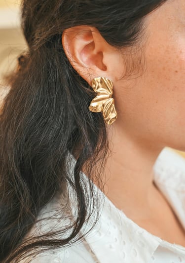 Stilingi aukso spalvos auskarai su unikalia tekstūra. Modernus ir ryškus papuošalas, suteikiantis įvaizdžiui elegancijos.