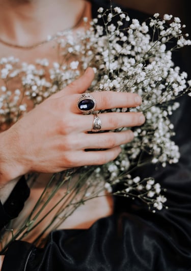 Masyvus sidabrinis žiedas su tamsiu akmeniu. Išskirtinis vintažinio stiliaus papuošalas, suteikiantis rankoms charakterio.