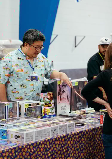 A vendor gestures to some of the nerdy items he has for sale.