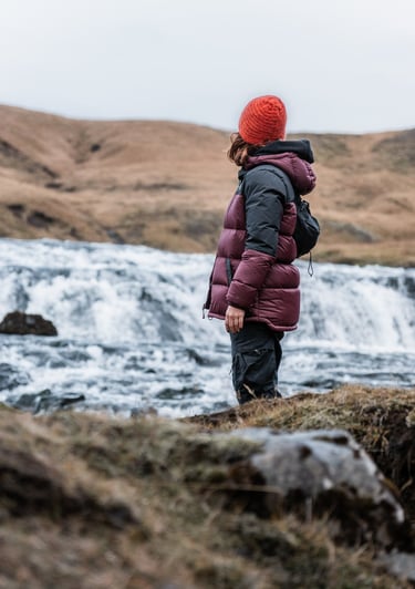 a person standing on a hill with a backpacker