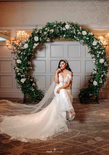 Bride posing under floral arch in wedding gown – Oxford wedding photography by Fred Art Studio